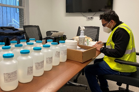 Rows of labeled water sample bottles prepared by an IEI technician for laboratory analysis